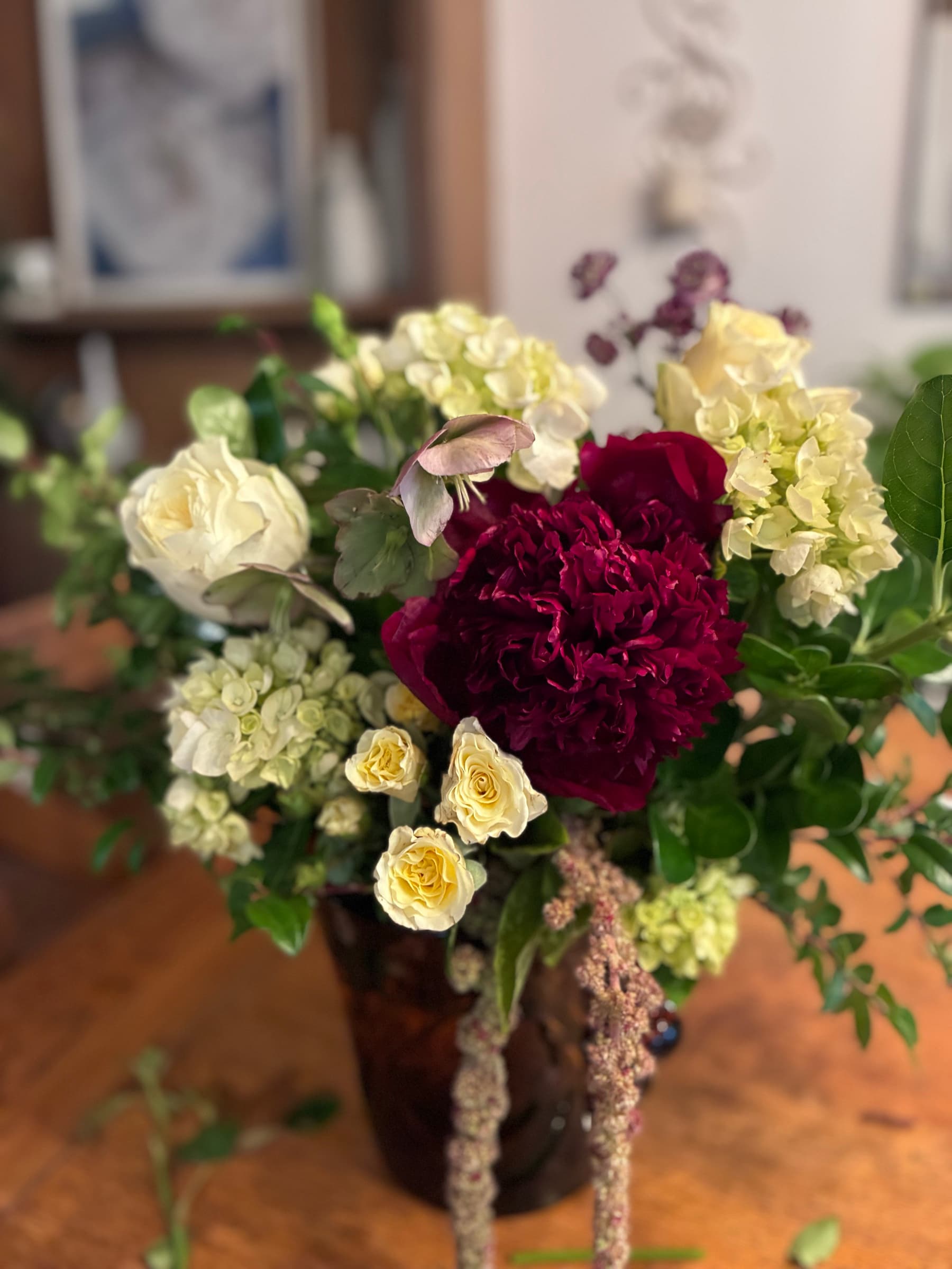 Burgundy carnations with cream roses and hydrangea