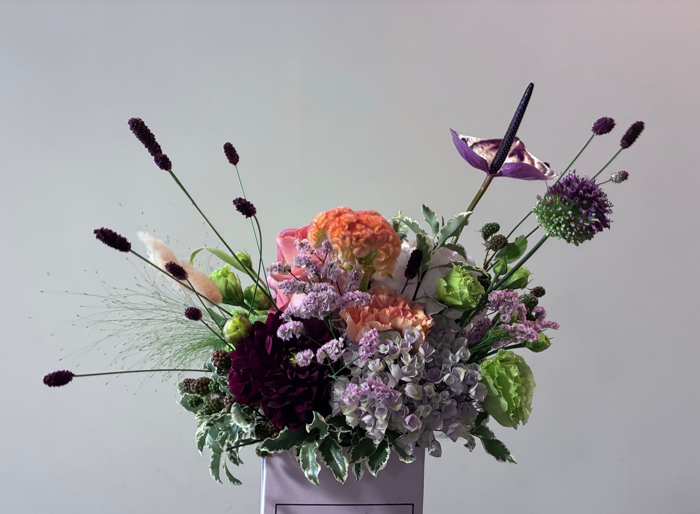 Lavender, allium and burgundy blooms in a sculptural arrangement