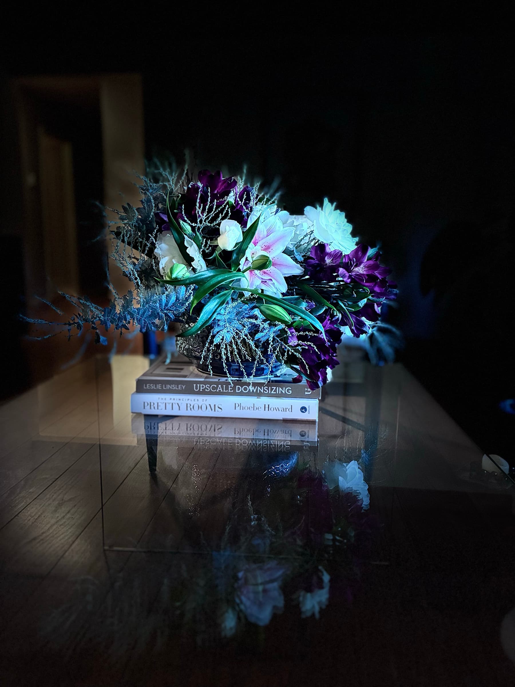 Purple and white arrangement on a stack of books